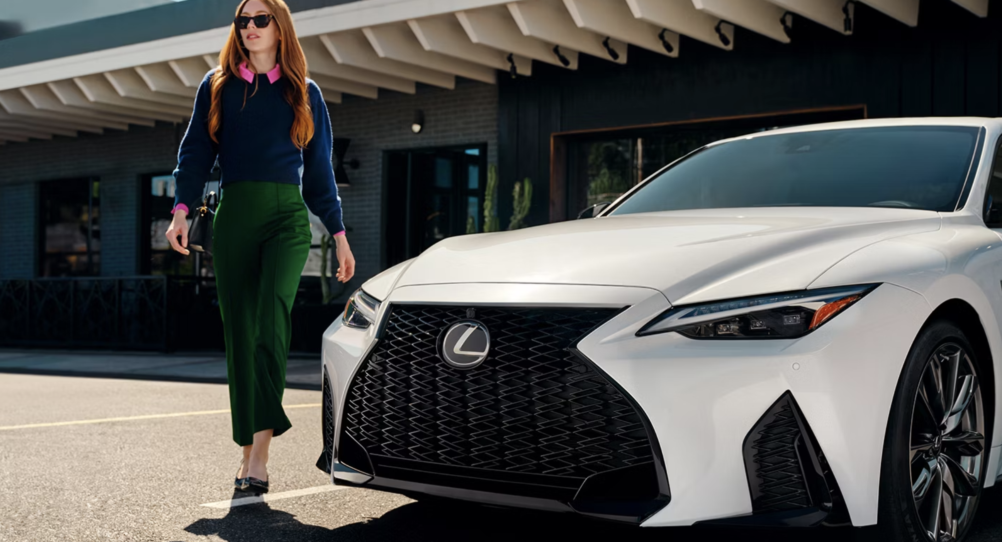 Woman walking around a 2025 Lexus IS